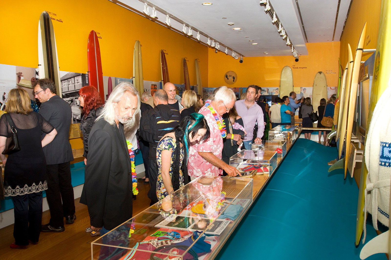 Crowds examining pieces at the Surf City exhibition opening