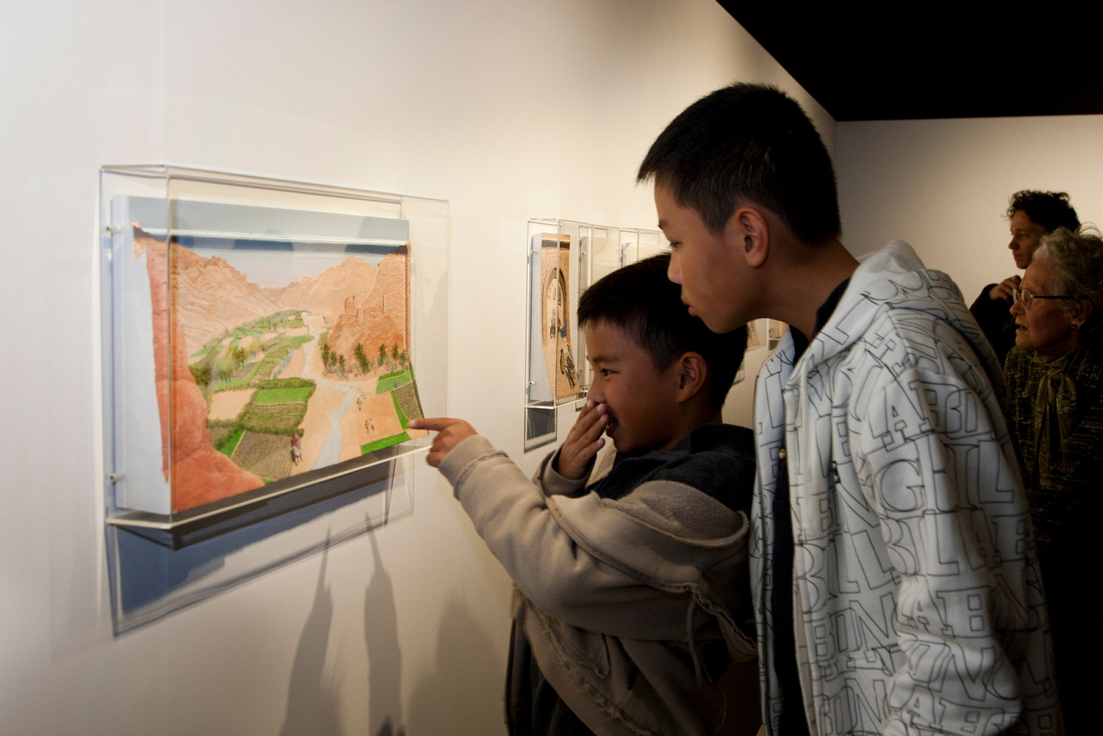 Children looking at artworks in Theme Gallery exhibition space