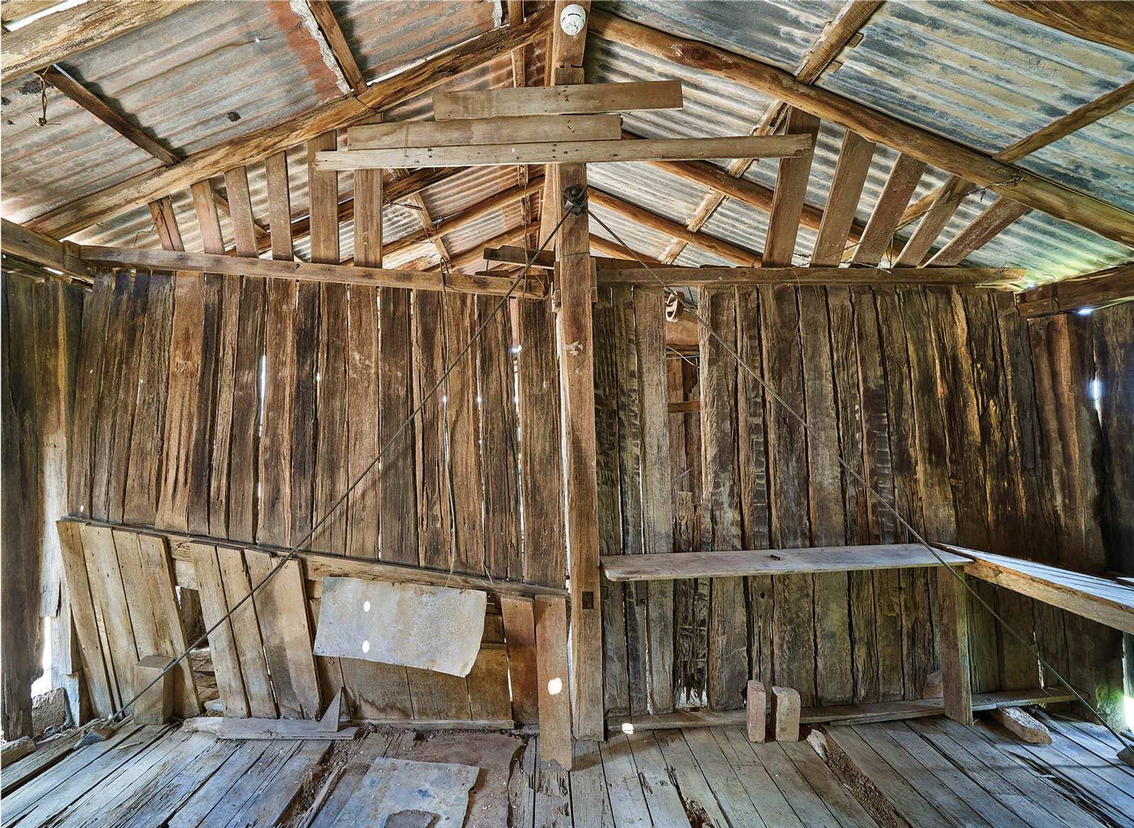 Dilapidated timber shed partition wall showing steel cross bracing