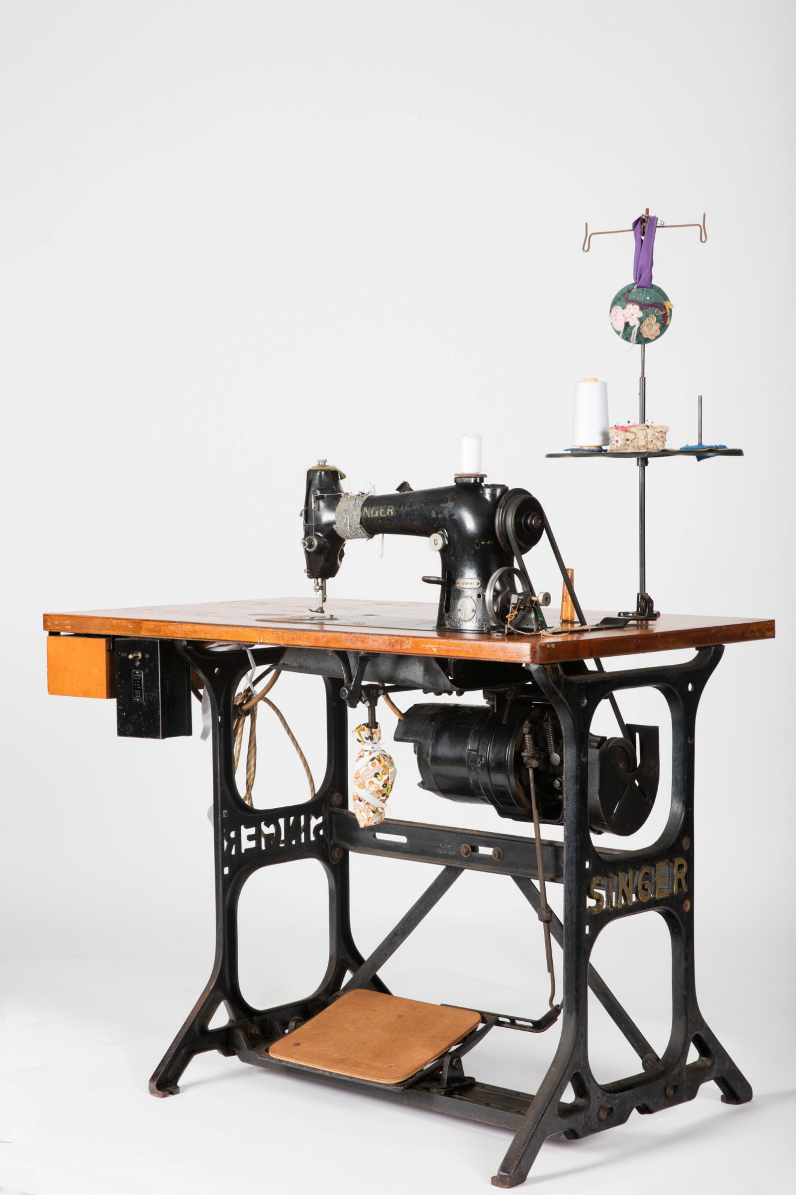 Metal framed sewing machine table with machine embedded.