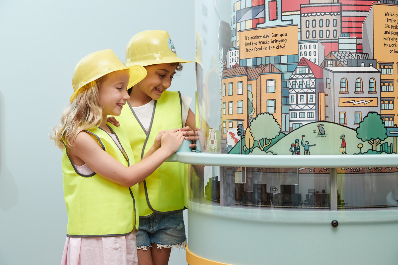 Young visitors interacting with a display at the How Cities Work exhibition held at the Museum of Sydney