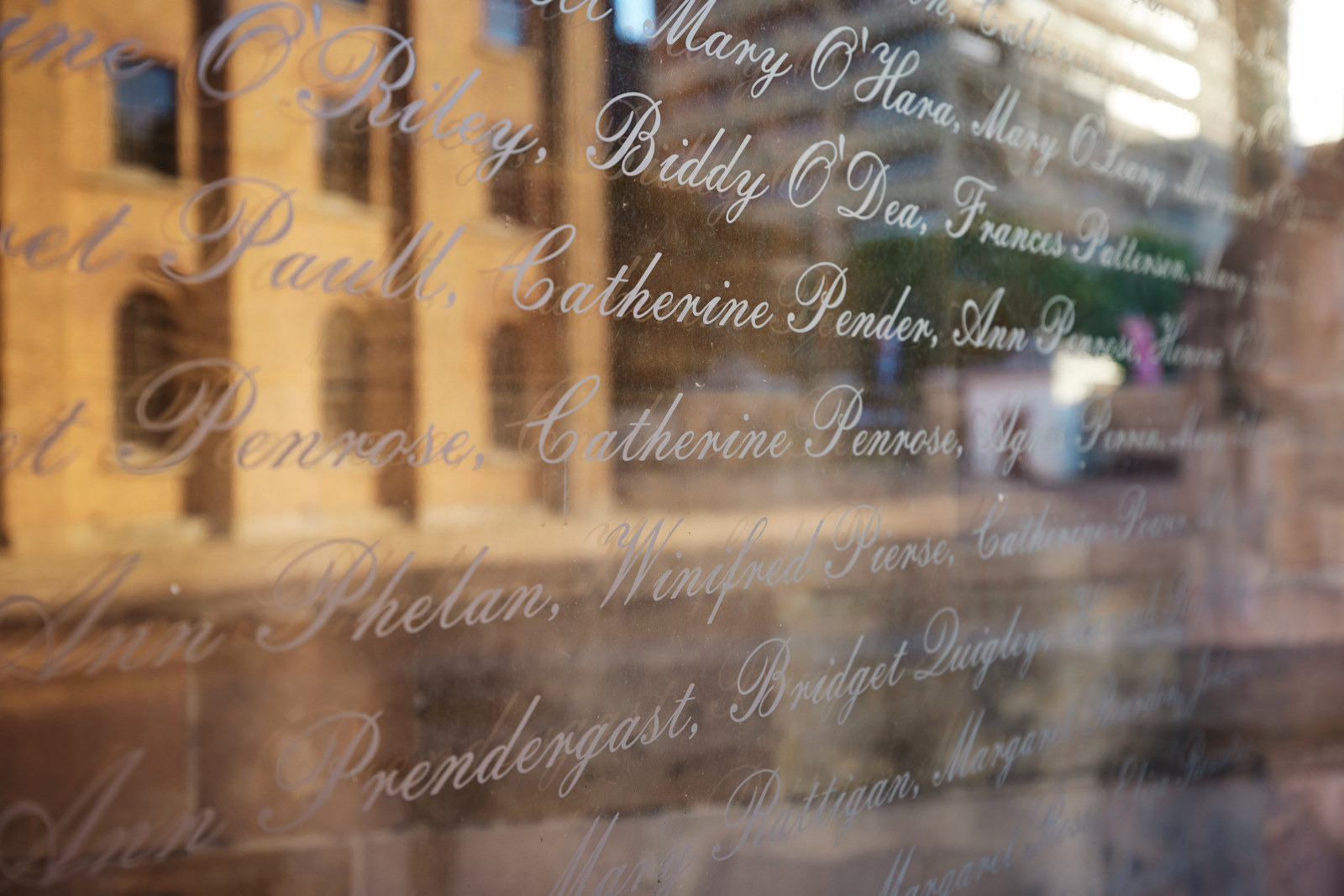 A reflection of the Hyde Park Barracks on the glass as part of 'An Gorta Mor', The Australian Monument to the Great Irish Famine