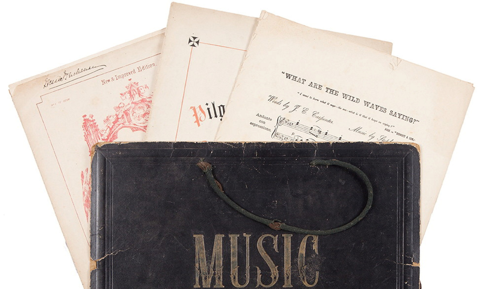 Sheet music sticking out of top of leather bound book with the word Music on its cover.