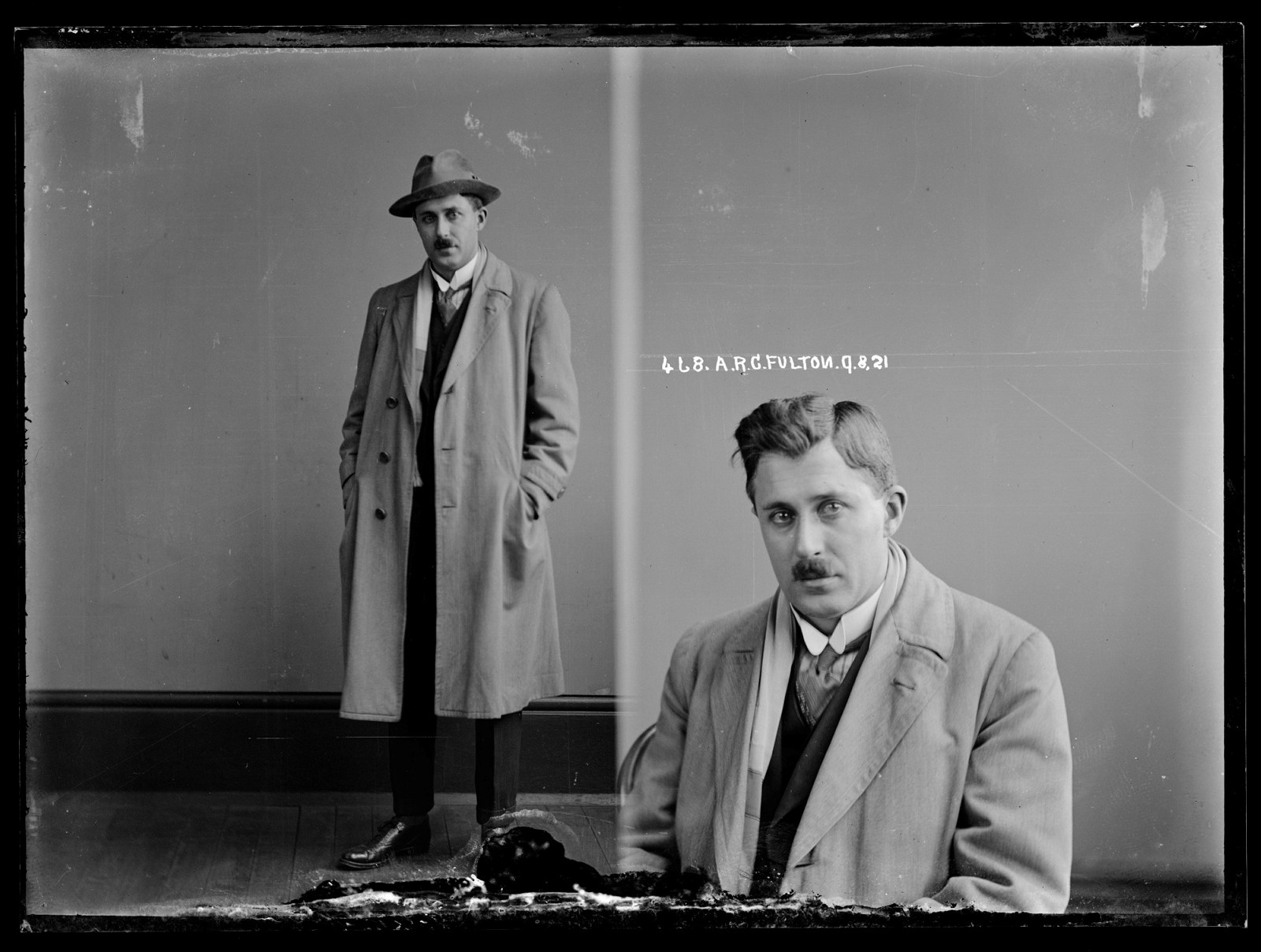 Dual black and white mugshot, man standing with hat on (left) and seated (right).