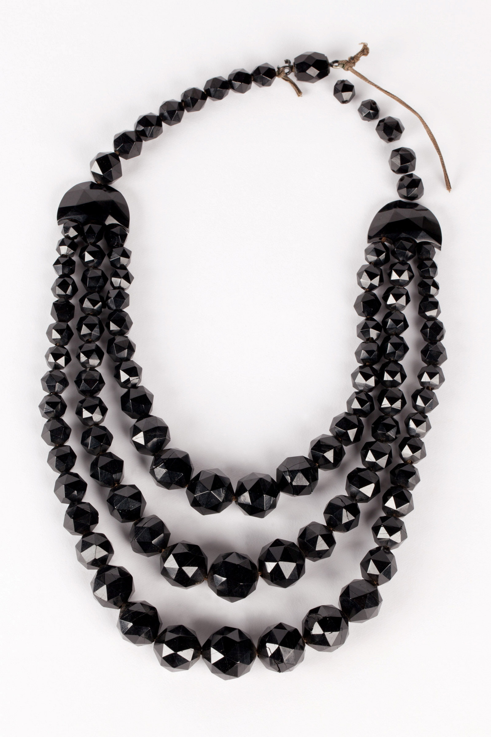 Jet necklace, a single strand of faceted beads from which hang three strands of graduated beads, 1880-1884