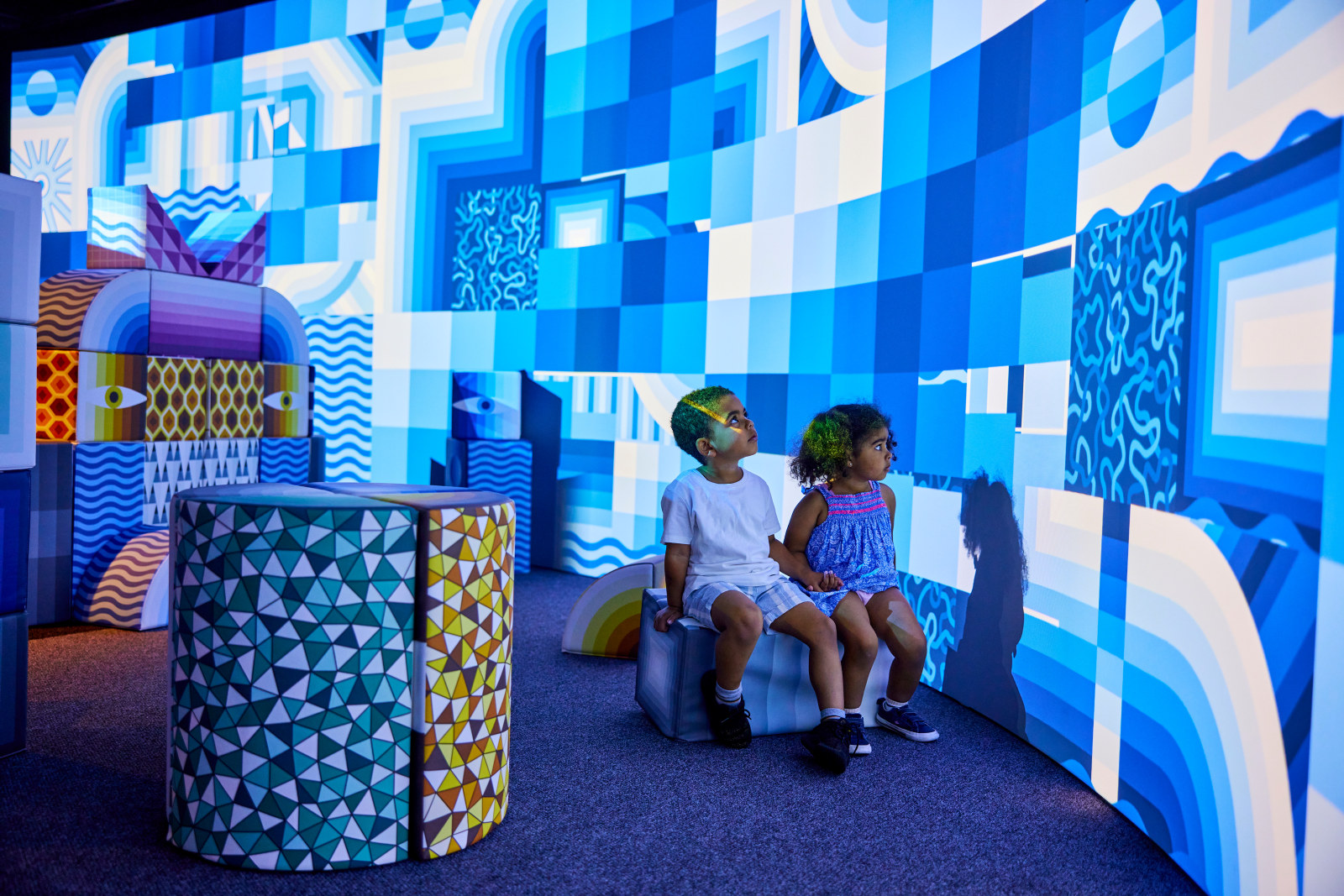 Young visitors watch the changing digital illustrations at PlayScapes at the Museum of Sydney