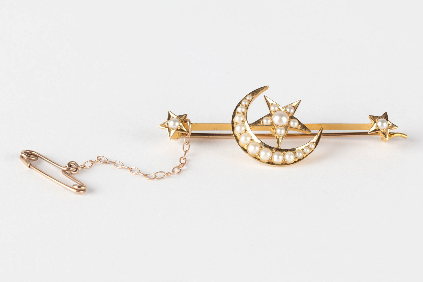 Gold bar brooch with a star and crescent moon design set with pearls, circa 1886