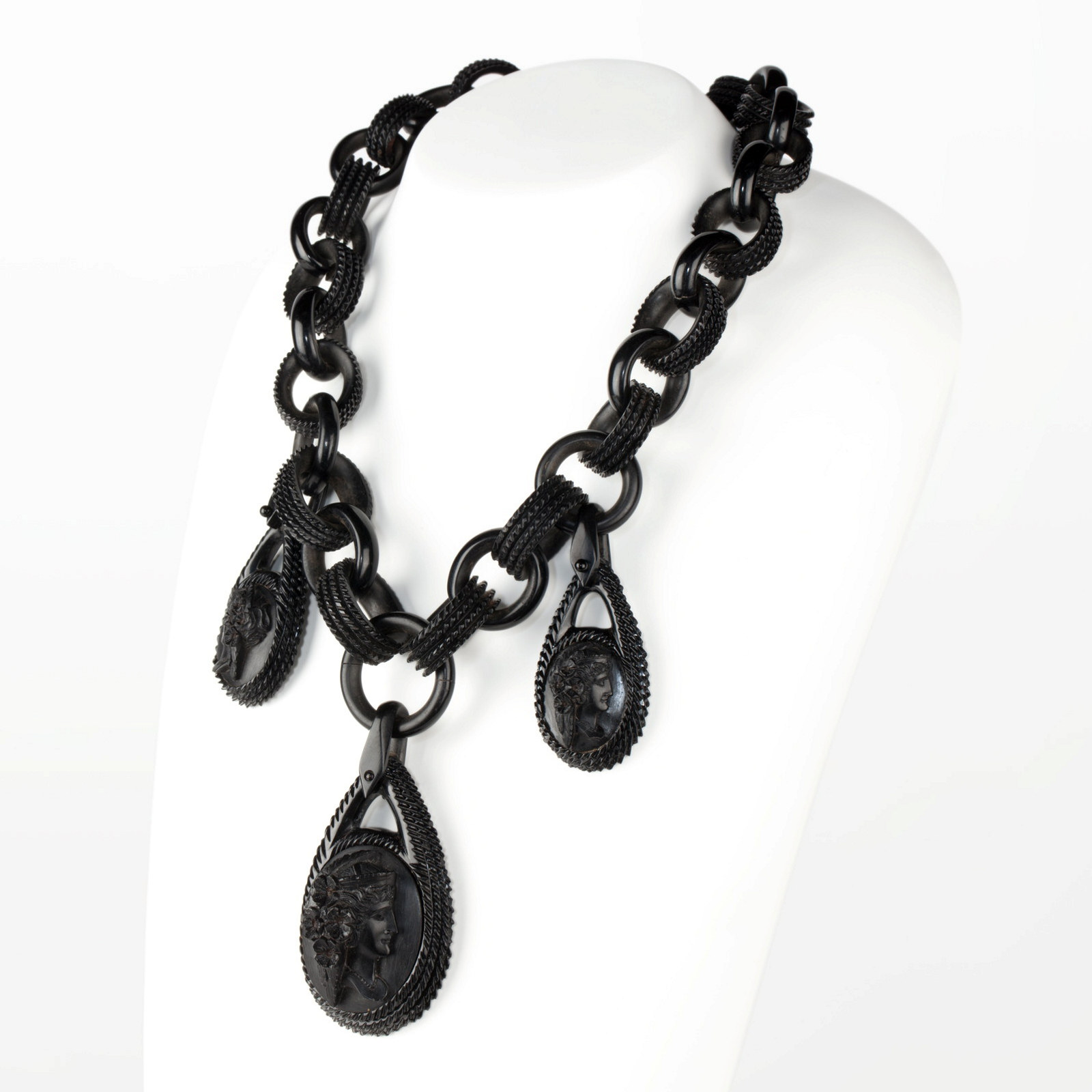 A vulcanite necklace composed of 32 graduating oval links and three oval pendants.