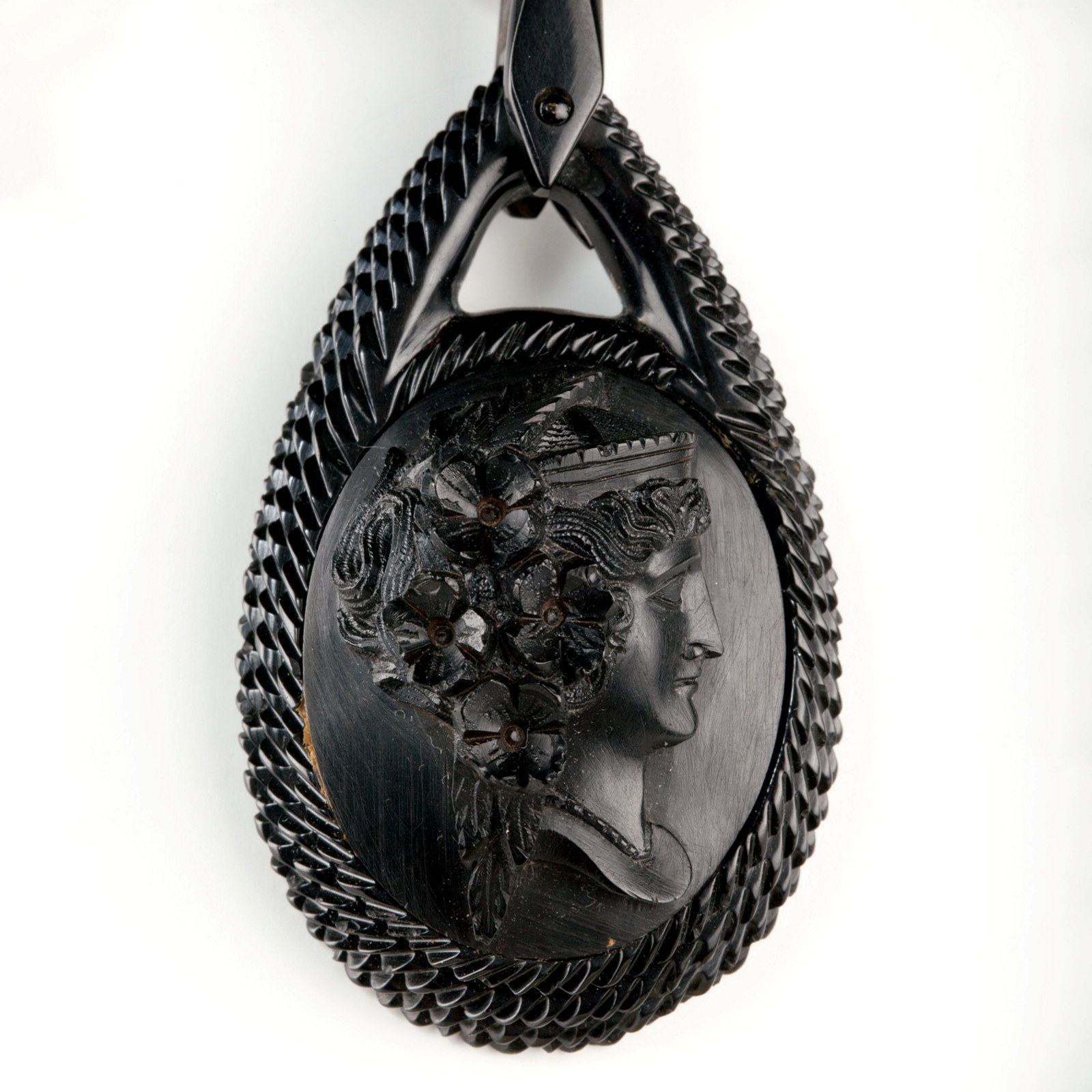 Detail view of pendant on a vulcanite necklace. The necklace is composed of 32 graduating oval links and three oval pendants.