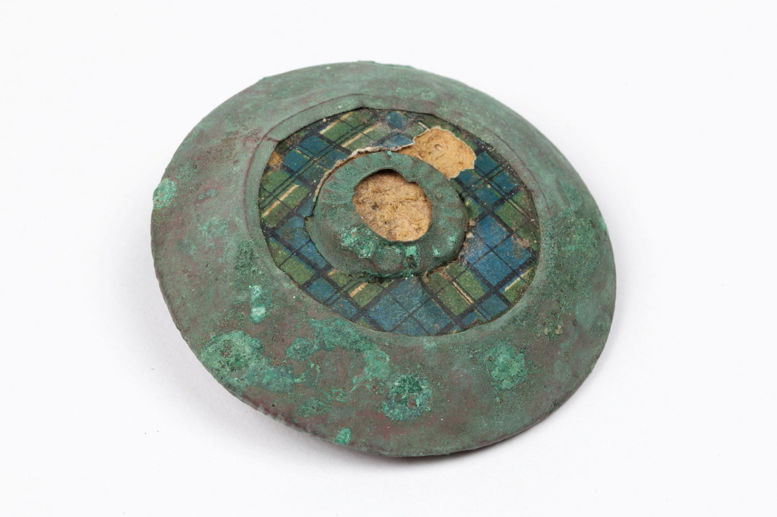 Copper brooch with green patina, green and blue check central inlay, excavated from beneath the floorboards of Hyde Park Barracks