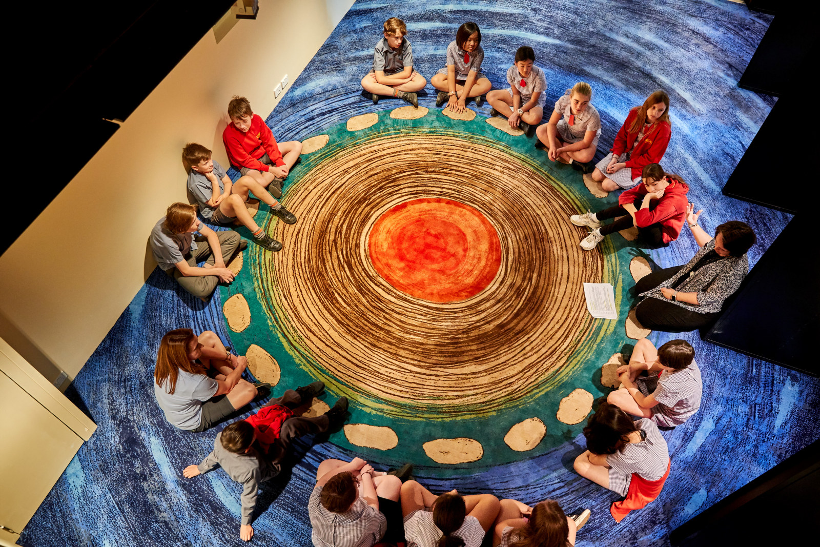 Students sitting around the Yarning Circle sharing stories as part of the Garuwanga Gurad (Stories that belong to Country) program at the Museum of Sydney