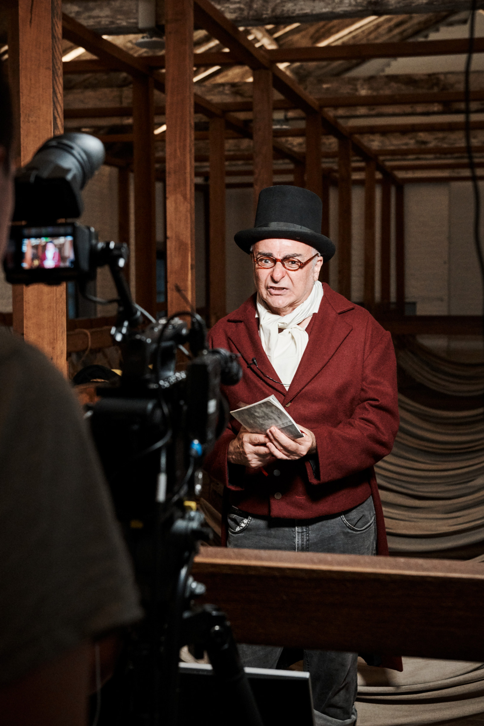 A Curriculum Program Deliverer performs as a costumed character in front of a camera in the hammocks room.