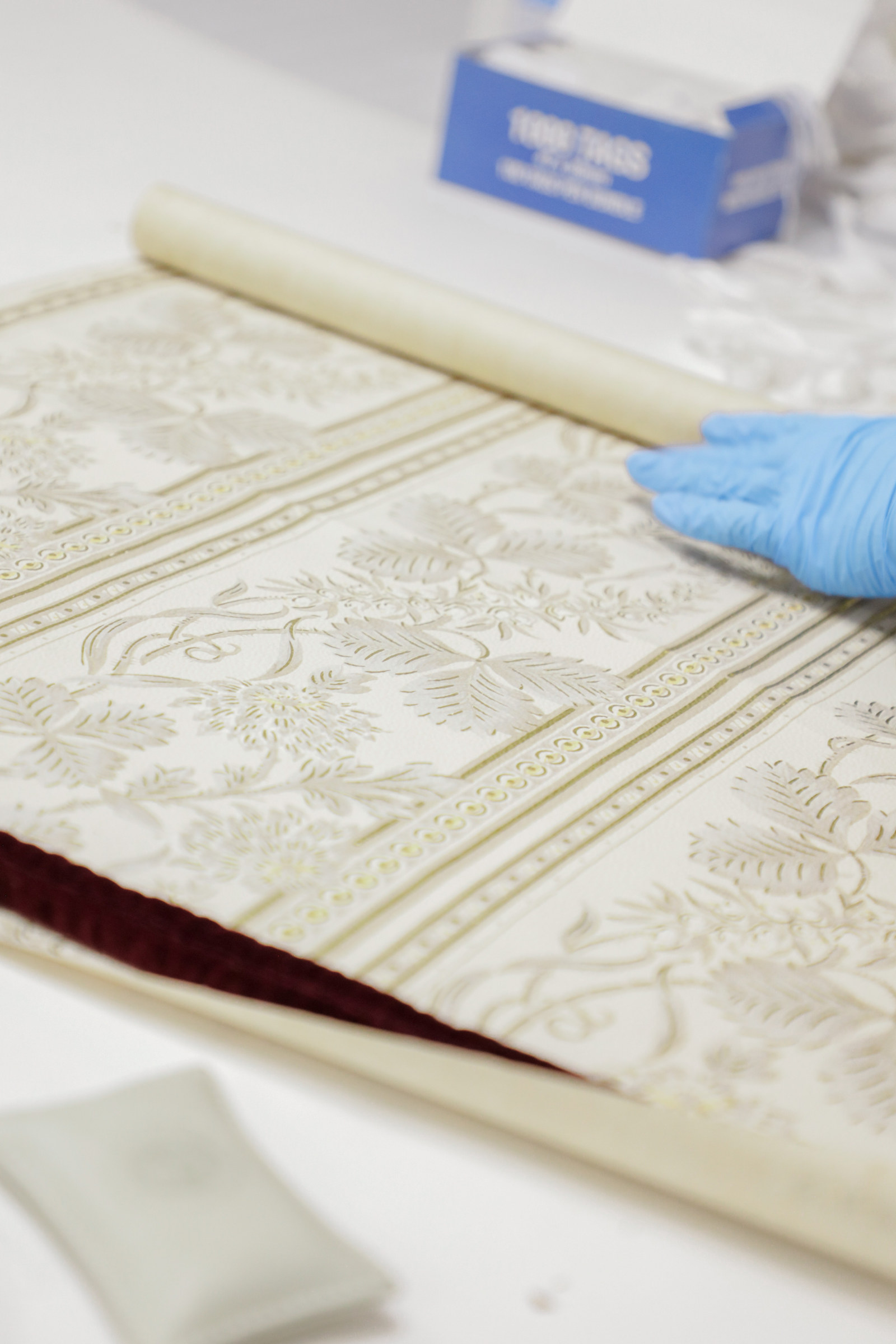 A wallpaper from the John and Phyllis Murphy collection being assessed, Museums Discovery Centre